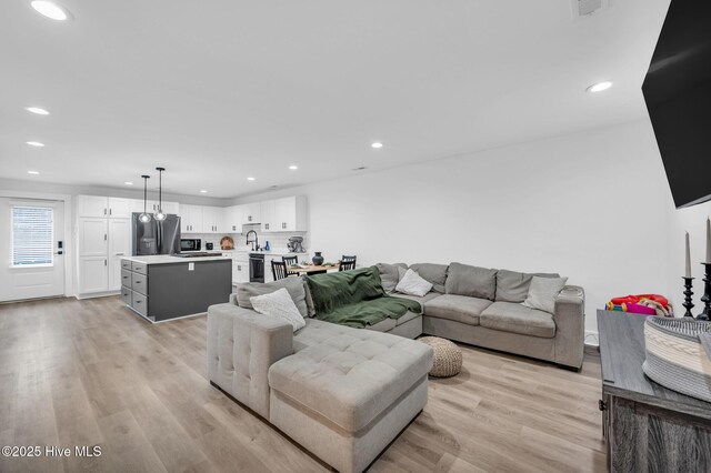 living area featuring recessed lighting and light wood-style flooring