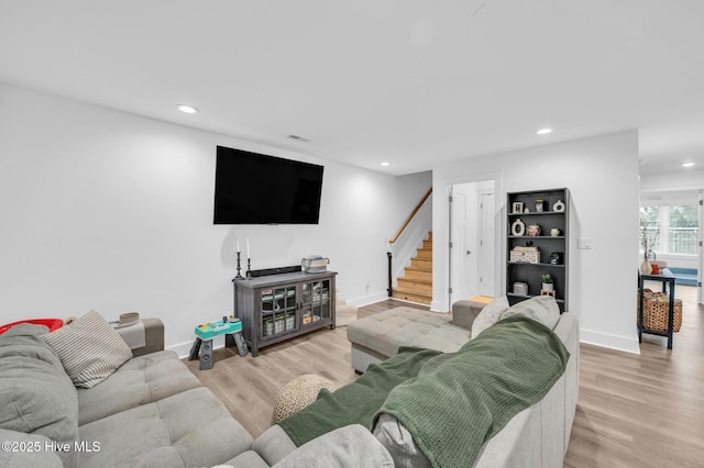 living area featuring light wood finished floors, stairway, recessed lighting, and baseboards