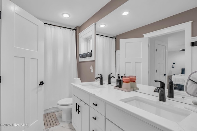 bathroom with a sink, toilet, marble finish floor, and ensuite bathroom