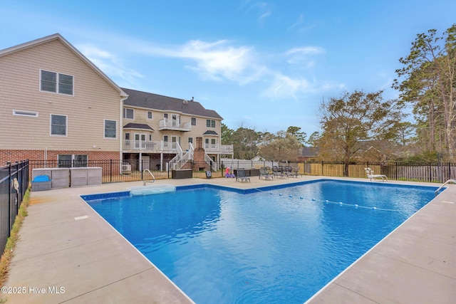 view of pool with fence, a patio, and stairway