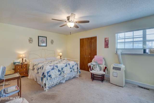 bedroom featuring carpet, visible vents, ceiling fan, and a textured ceiling