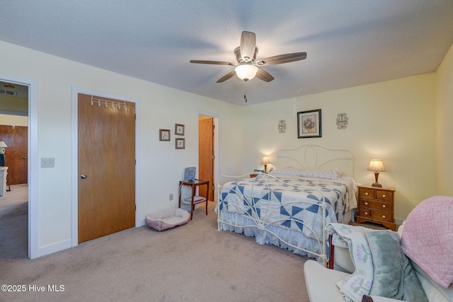 carpeted bedroom featuring a closet, ceiling fan, and a textured ceiling