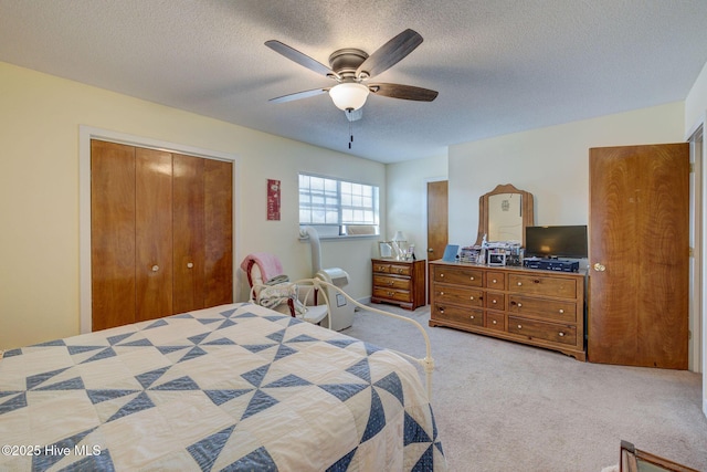 bedroom with a ceiling fan, a closet, carpet flooring, and a textured ceiling