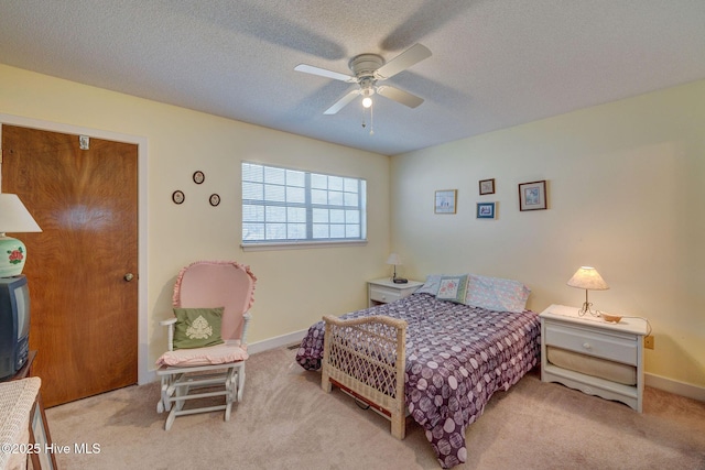 carpeted bedroom featuring a ceiling fan, a textured ceiling, and baseboards