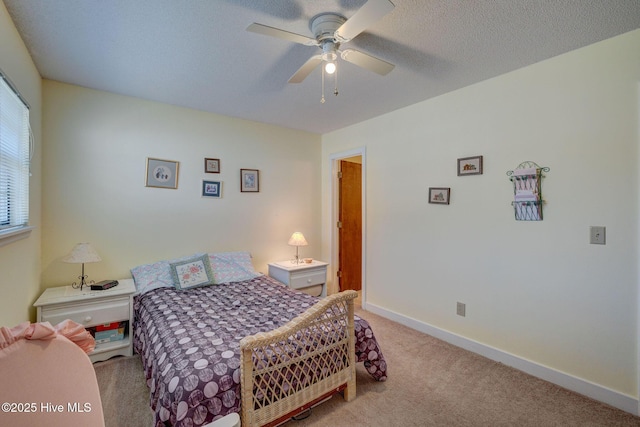 bedroom featuring a textured ceiling, baseboards, a ceiling fan, and light colored carpet