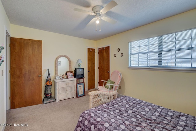 bedroom featuring carpet floors, a textured ceiling, and a ceiling fan