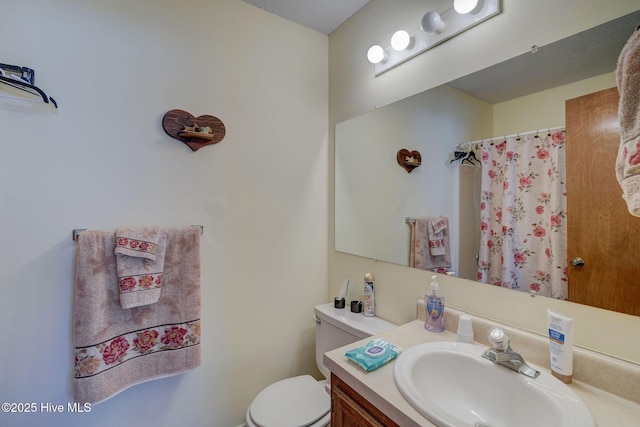 bathroom featuring a shower with curtain, vanity, and toilet