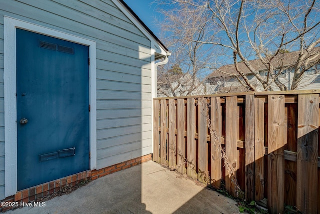 property entrance with fence and visible vents