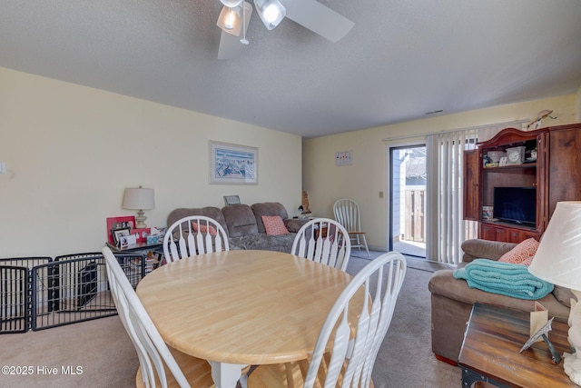 dining area featuring ceiling fan, a textured ceiling, and carpet flooring