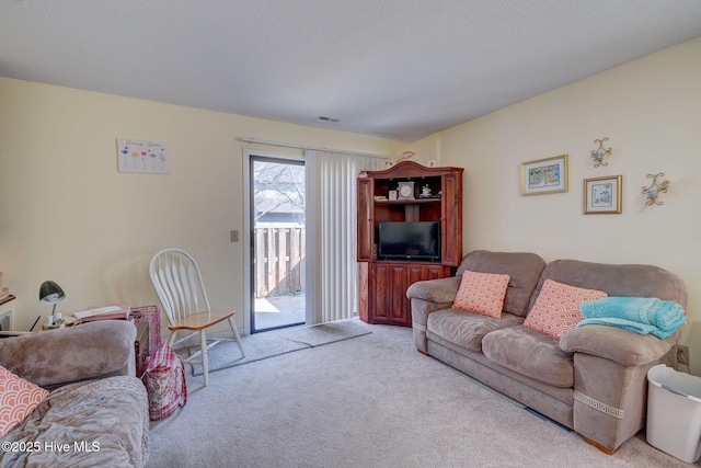 carpeted living room with visible vents and a textured ceiling