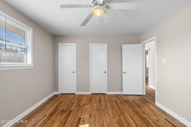 unfurnished bedroom featuring ceiling fan, baseboards, and wood finished floors