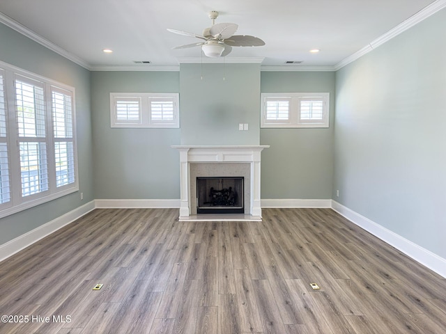 unfurnished living room with a fireplace with raised hearth, crown molding, and baseboards