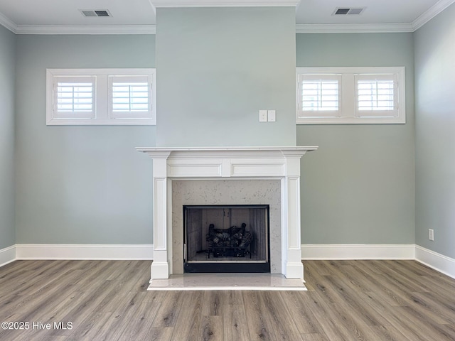 unfurnished living room featuring crown molding, visible vents, and a fireplace