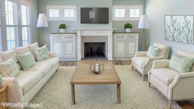 living area with light wood-type flooring and a premium fireplace