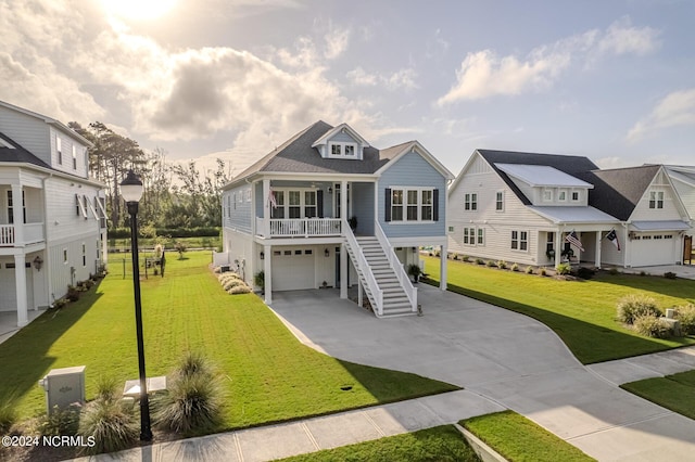 beach home featuring concrete driveway, stairway, an attached garage, a residential view, and a front lawn