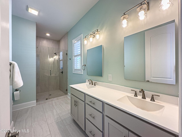 bathroom featuring a sink, a shower stall, baseboards, and double vanity