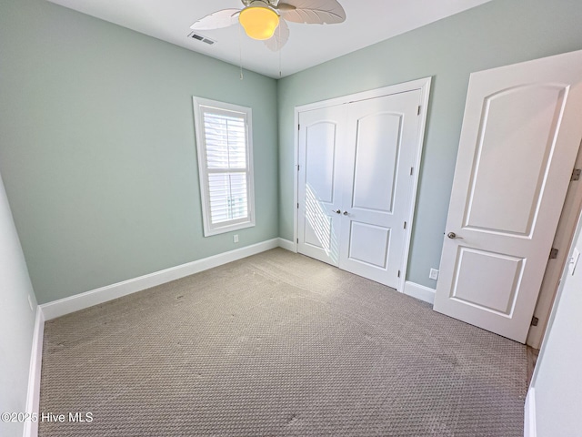 unfurnished bedroom with a ceiling fan, visible vents, baseboards, a closet, and carpet