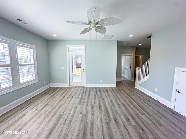 spare room featuring wood finished floors, visible vents, and baseboards