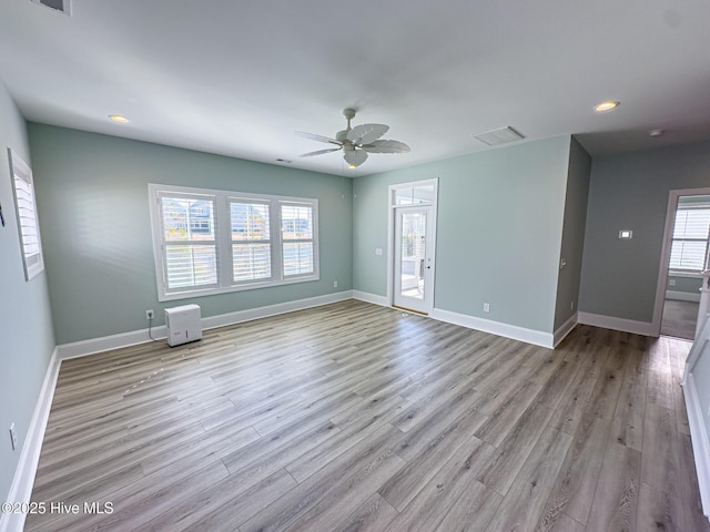 empty room featuring visible vents, baseboards, and wood finished floors