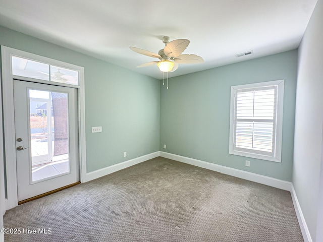 spare room featuring a ceiling fan, carpet, visible vents, and baseboards