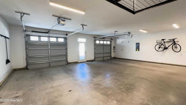 garage with electric panel, baseboards, and a garage door opener