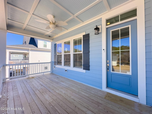 wooden deck featuring covered porch and a ceiling fan