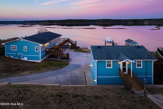 view of front of home with a water view, stairs, and concrete driveway