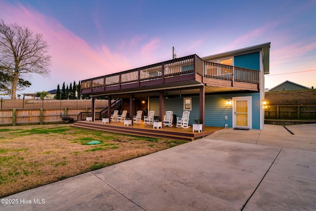 back of house with a lawn, fence, a deck, and a patio