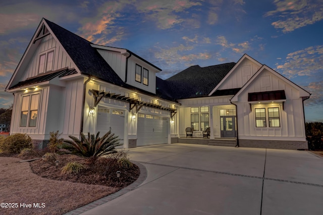 modern farmhouse with roof with shingles, concrete driveway, board and batten siding, a standing seam roof, and a garage