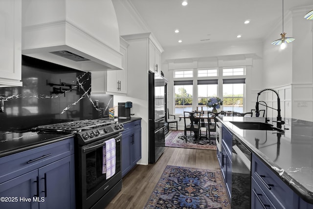 kitchen featuring a sink, appliances with stainless steel finishes, custom exhaust hood, and blue cabinets