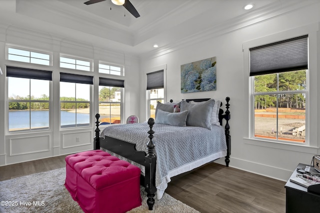 bedroom featuring dark wood-style floors, ornamental molding, and multiple windows