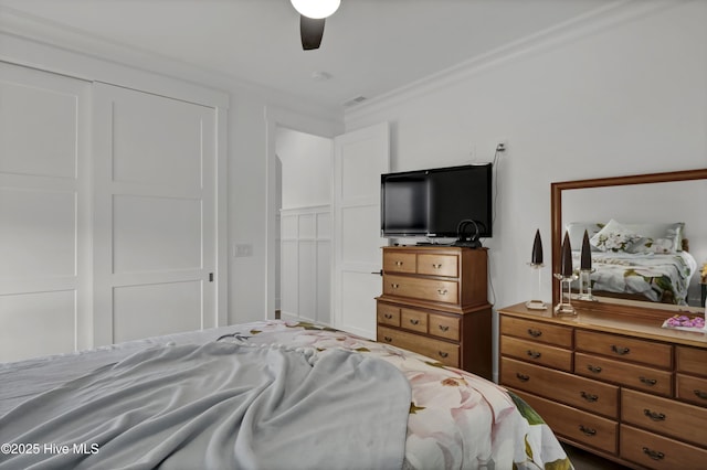 bedroom with a closet, a ceiling fan, and crown molding