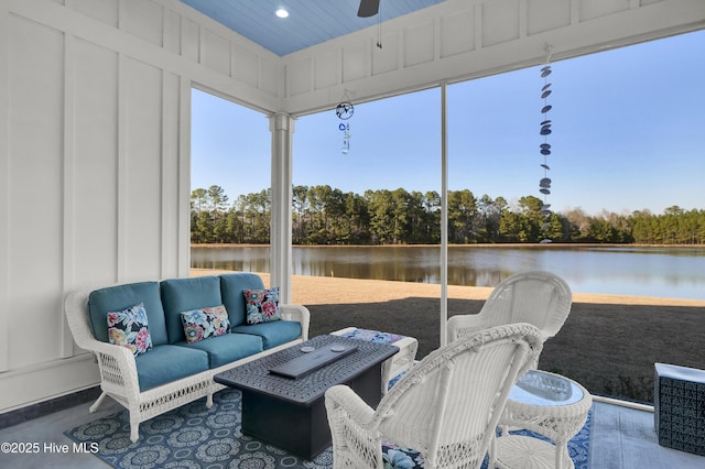 sunroom with a water view and a ceiling fan