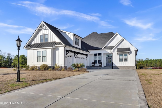 modern farmhouse style home featuring driveway, a standing seam roof, metal roof, and board and batten siding