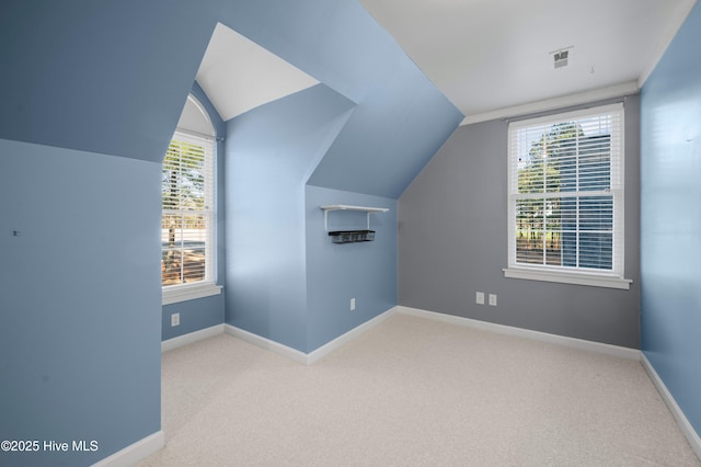 bonus room featuring lofted ceiling, visible vents, light carpet, and baseboards