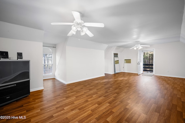 unfurnished living room featuring a healthy amount of sunlight, wood finished floors, and lofted ceiling