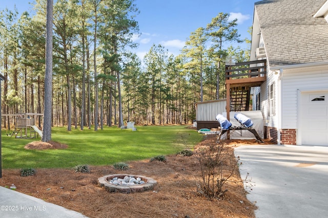 view of yard with stairs, a deck, and a garage