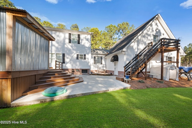 back of property with entry steps, stairs, a lawn, and a patio