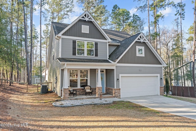 craftsman-style home featuring central AC unit, a porch, brick siding, fence, and driveway