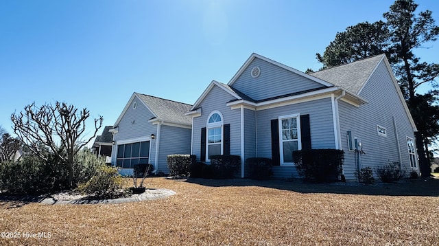 view of front of property featuring entry steps, a front yard, and an attached garage