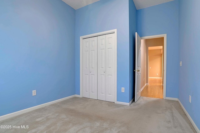 unfurnished bedroom featuring baseboards, a closet, and carpet