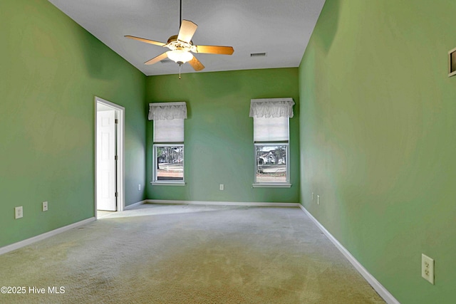 carpeted empty room with visible vents, baseboards, and ceiling fan