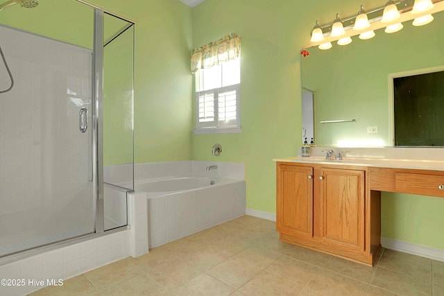 bathroom with tile patterned floors, a stall shower, baseboards, a garden tub, and vanity