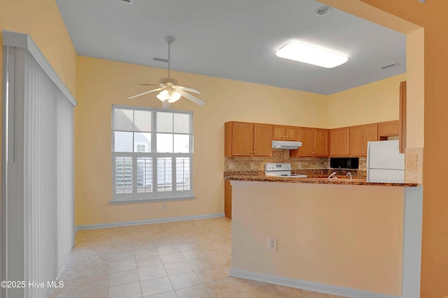 kitchen with dark stone counters, decorative backsplash, white appliances, ceiling fan, and under cabinet range hood