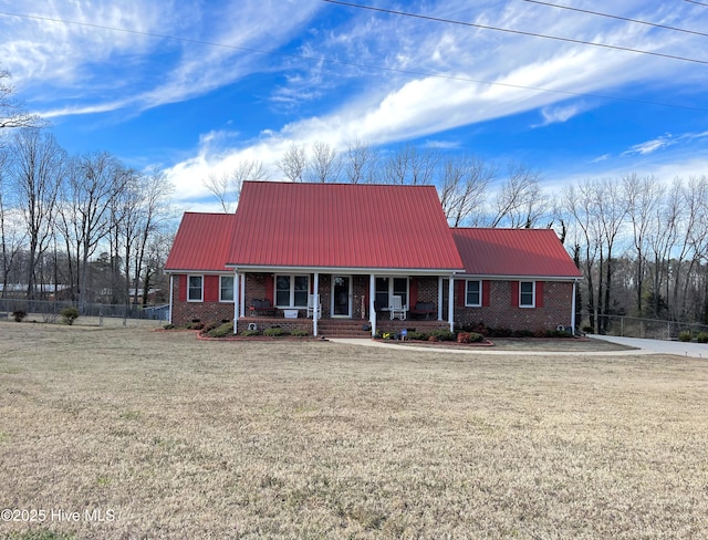 view of front of house with covered porch, metal roof, and brick siding