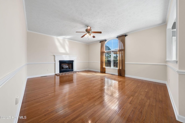 unfurnished living room with a brick fireplace, crown molding, and hardwood / wood-style flooring