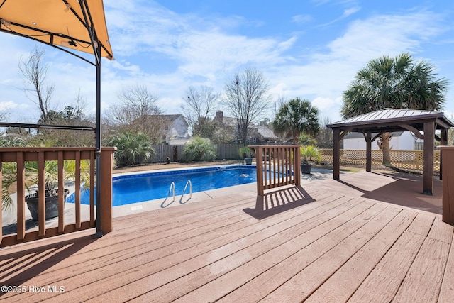 view of pool featuring a gazebo, a fenced backyard, a wooden deck, and a fenced in pool