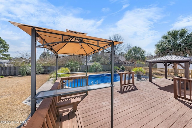 wooden deck featuring a gazebo, a fenced backyard, and a fenced in pool