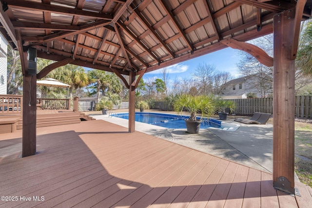 view of pool featuring a gazebo, a fenced backyard, a wooden deck, and a fenced in pool