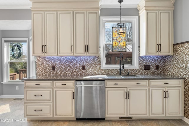 kitchen with dark countertops, cream cabinets, and stainless steel dishwasher